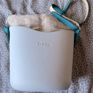 The original O Bag, cream with tan linen lining and turquoise shoulder strap